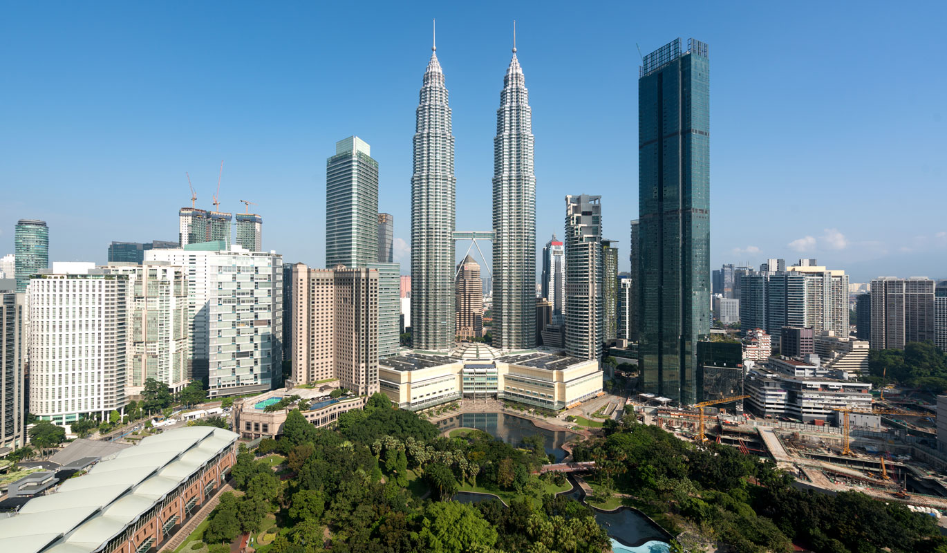 Kuala Lumpur skyline featuring the Petronas Twin Towers, prime property investment district with modern skyscrapers and green parkland